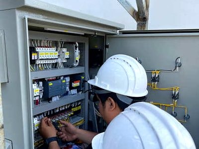 AIES technicians wiring a local control panel for booster pumps