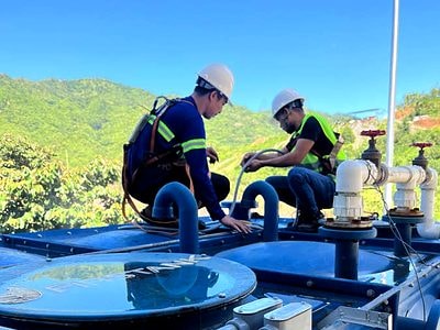 Technicians installing level instrumentation on water storage tanks