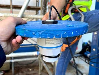 Close-up of a level float sensor being installed on a water storage tank